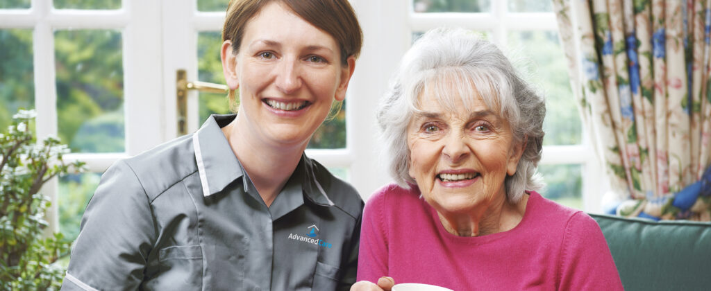 One of Advanced Care's home care assistant sitting with a service user 