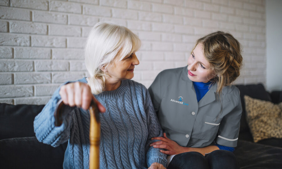 One of Advanced Care's home care assistant sitting with a service user