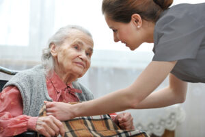 Carer putting a blanket on an elderly patient.